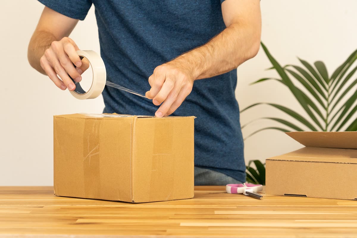 Sealing a package with plastic tape for shipping — 한국에서 사는 구매대행 경로 3가지